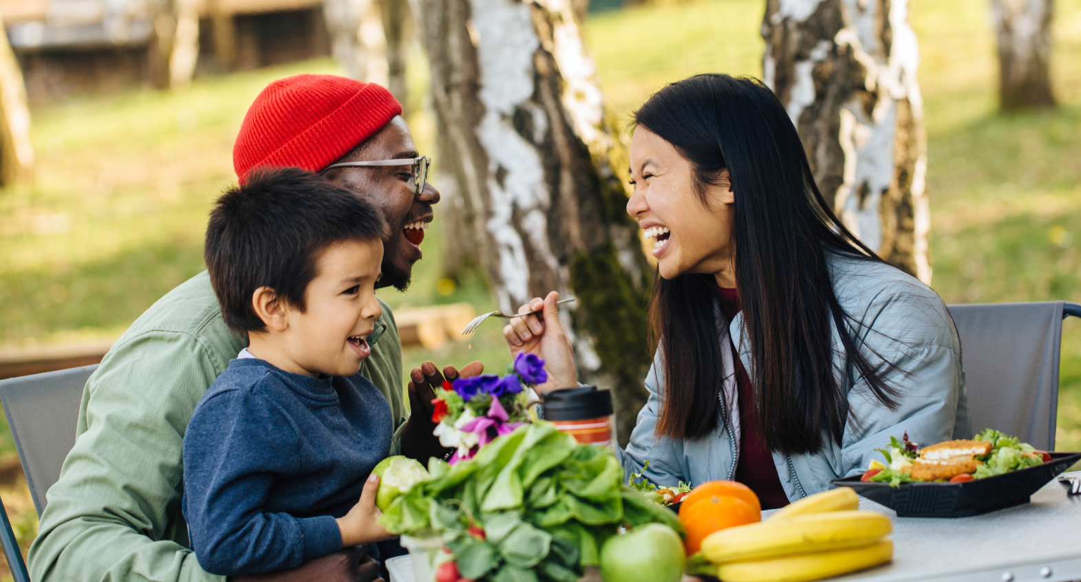 a family eating outdoors with a large bounty of fresh produce