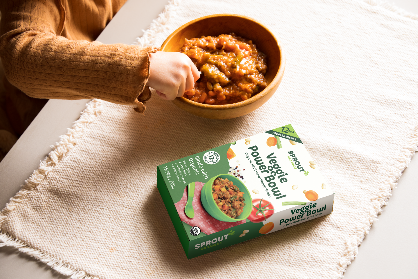 A toddler self feeding themself the veggie power bowl organic toddler meal