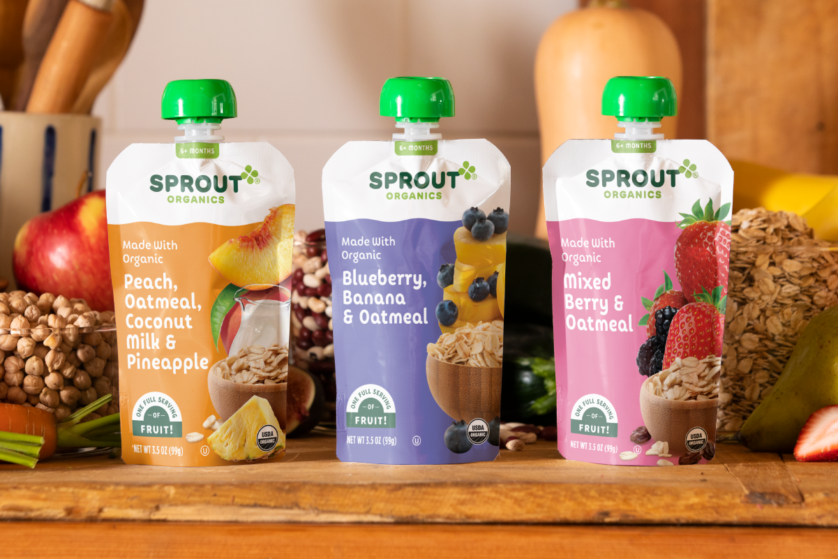 two sprout organics puffs baby snack sits on a counter with organic fruits vegetables and grains